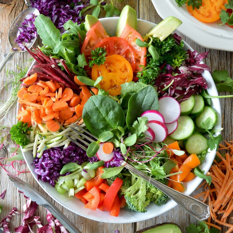 A spread of fresh vegetables, leaves and herbs