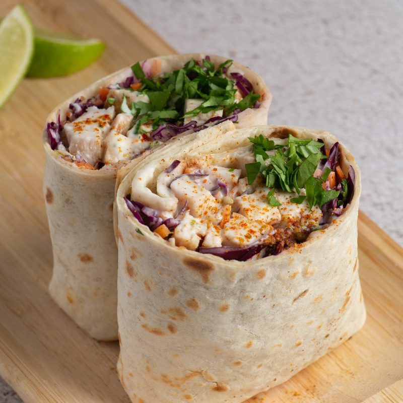 Two fresh wraps filled with chicken, slaw and herbs